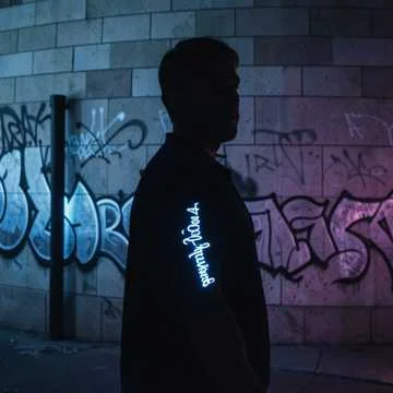 Streetlights paint our shadows on the grey stone wall